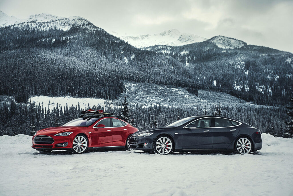 Unleashing the Power: Red and Black Tesla Model S P85D Cars Braving the Winter Wilderness Wallpaper
