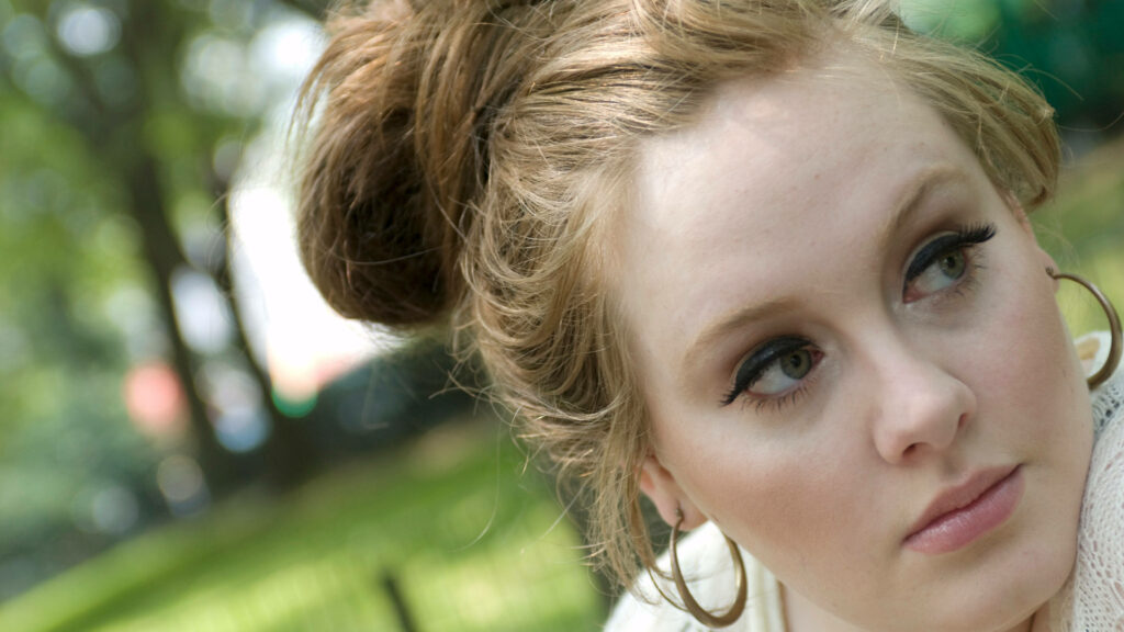 Elegant Adele Close-Up Wallpaper: Expressive Eyes & Nature Background