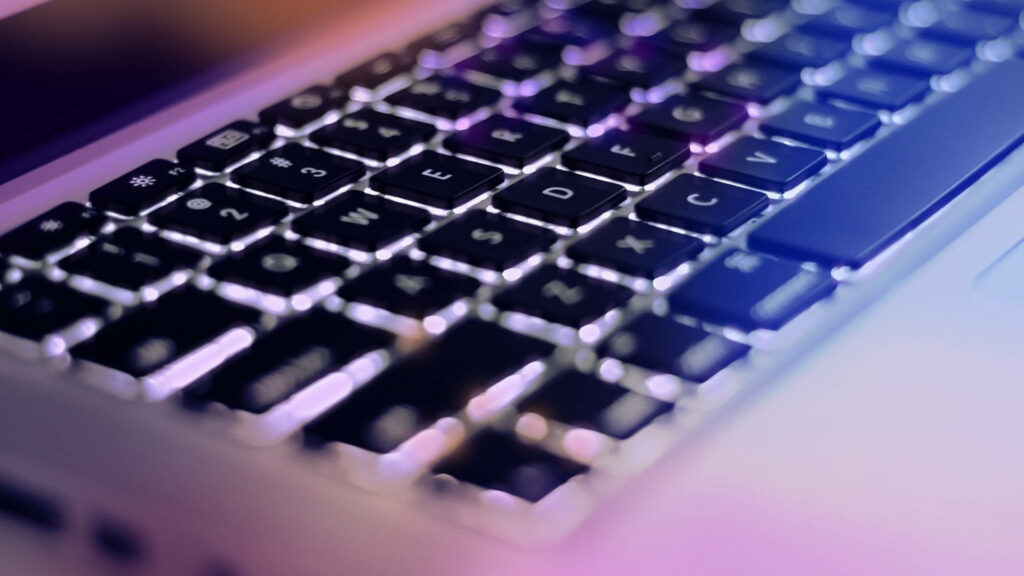 The Enchanting Glow: Keyboard Aesthetic Delight Captured in Hi-Tech Apple Laptop Background Wallpaper