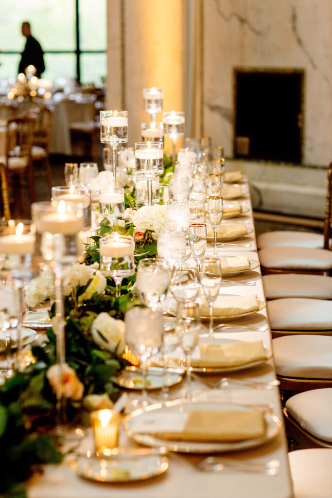 Elegant banquet table wallpaper with lush greenery roses and warm floating candlelight glow