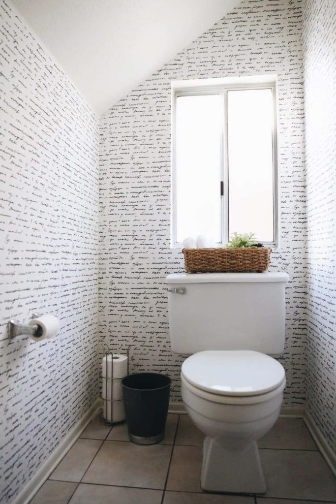 Elegant bathroom with black white handwritten script wallpaper and modern woven basket decor