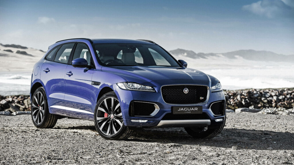 Sleek Blue Jaguar Wallpaper: Power & Elegance on Rugged Terrain