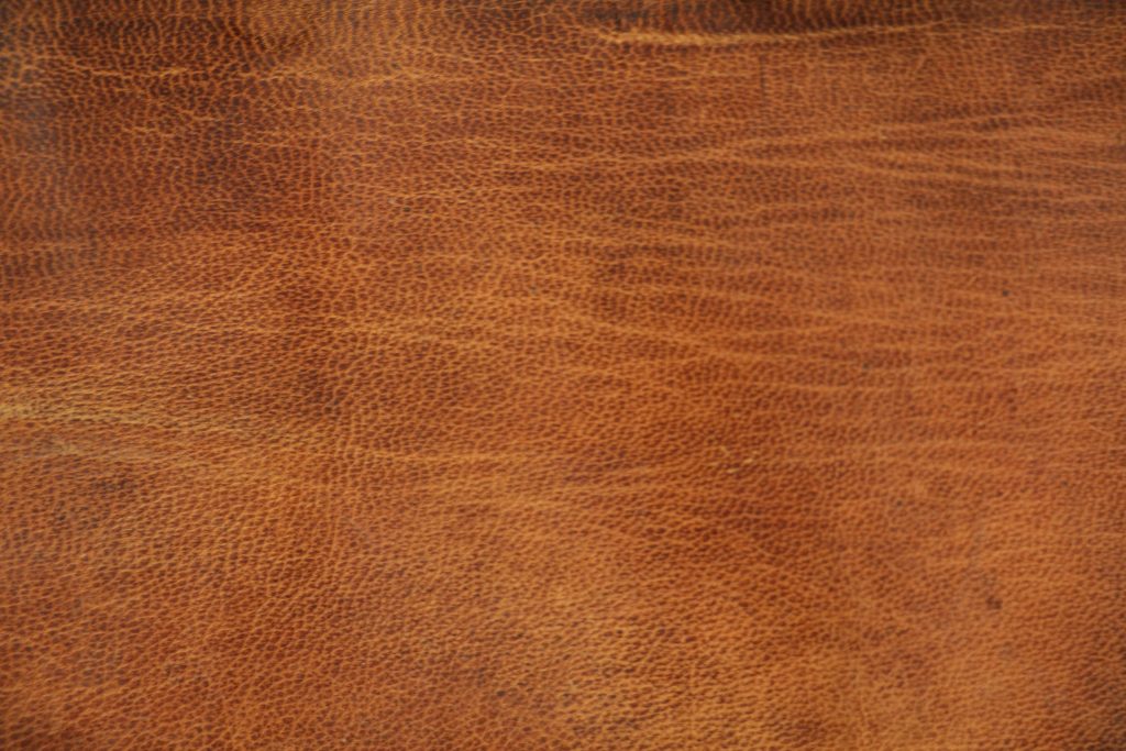 Close-up of rich brown leather wallpaper with detailed natural grain texture for elegant decor
