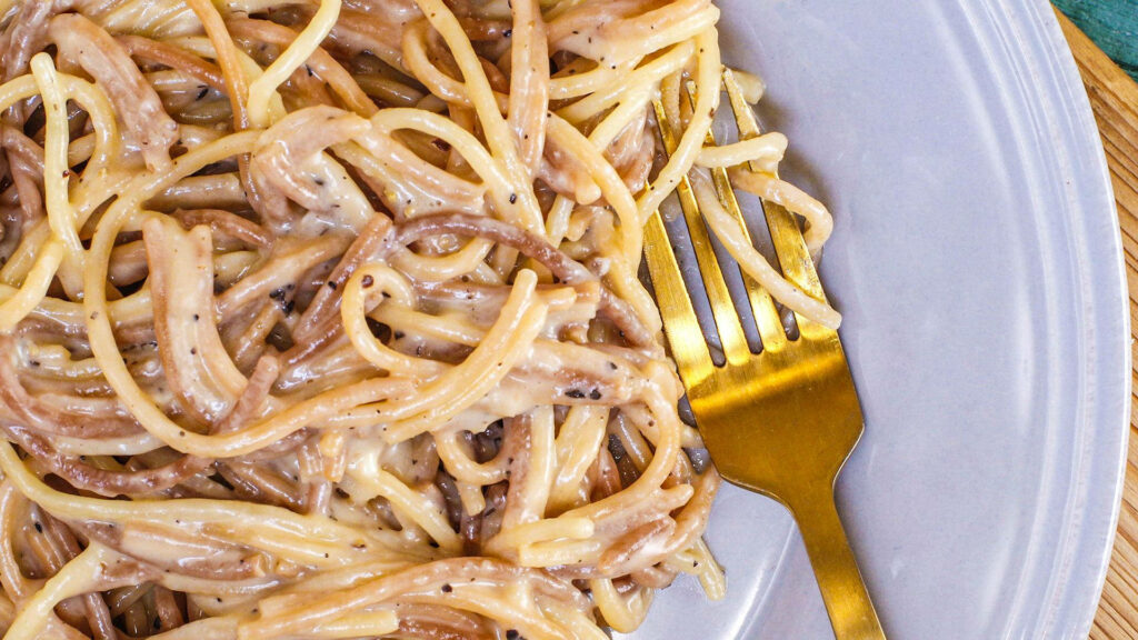 Elegant Cacio e Pepe Pasta Close-Up with Golden Fork - Wallpaper