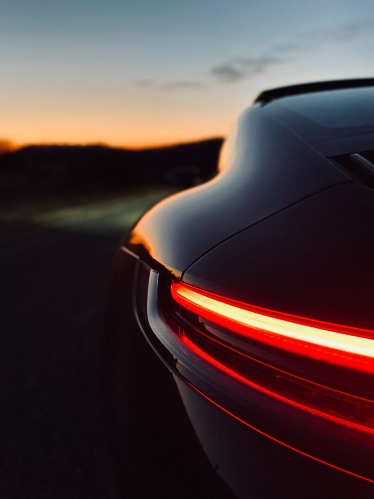Elegant Car Rear View at Sunset with Glowing Taillights Wallpaper