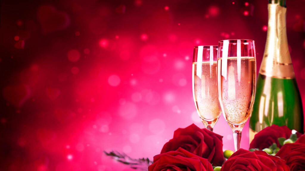 Elegant Champagne Flutes on Romantic Red Bokeh Background Wallpaper