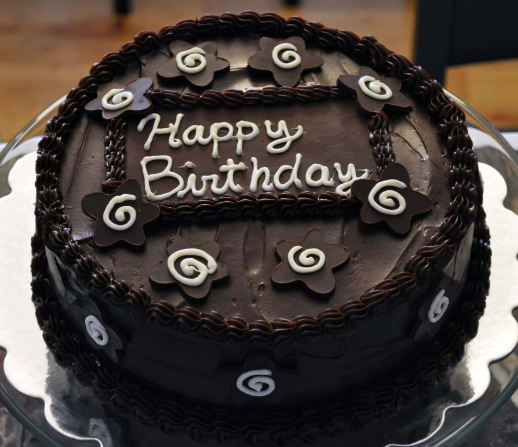 Elegant Chocolate Birthday Cake with Floral Swirls – Delightful Dessert Wallpaper