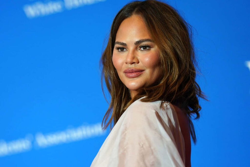 Elegant Chrissy Teigen Wallpaper: Vibrant Blue Backdrop at Event
