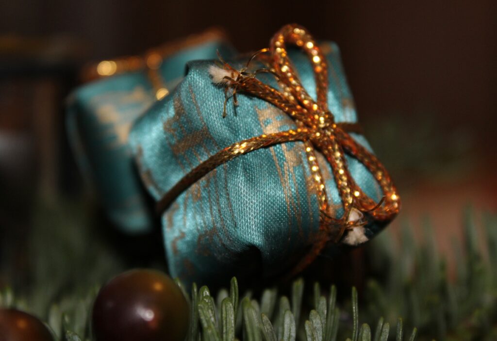 Elegant Gift Box Wallpaper: Golden Ribbon & Evergreen Background