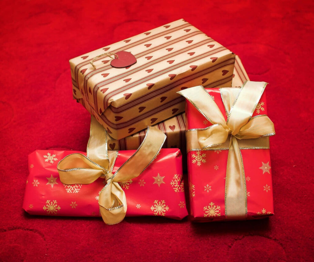 Elegant Christmas Gifts Wallpaper with Red Background & Gold Ribbons