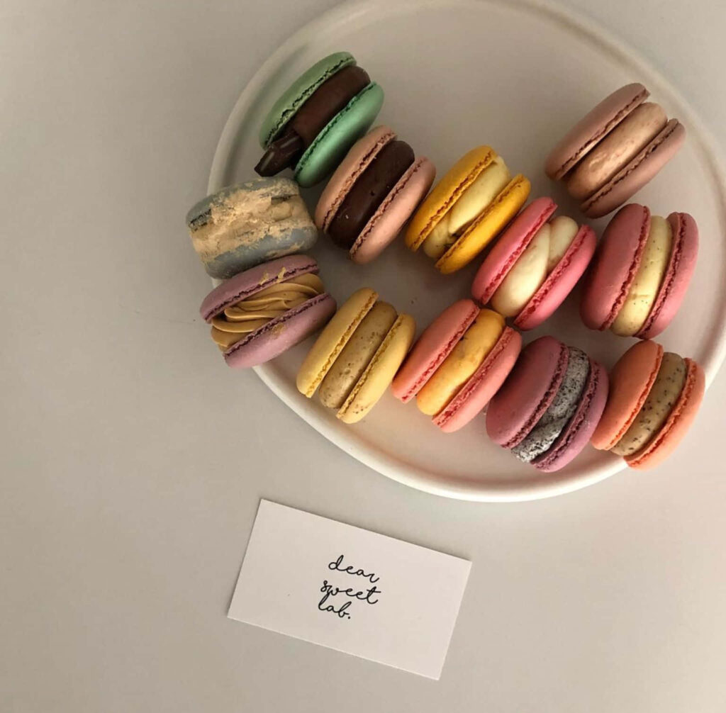 Elegant Macarons Display: Colorful Treats with 'Dear Sweet Lab' Wallpaper