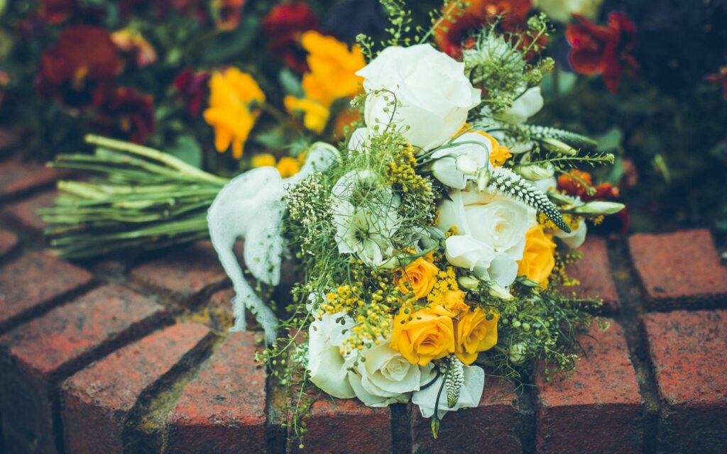 Elegant Floral Wallpaper: Creamy White & Yellow Roses on Brick