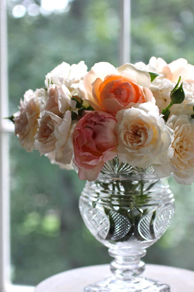 Elegant Crystal Vase with White and Peach Roses on Soft Green Background Wallpaper