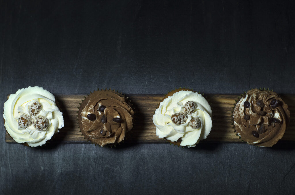 Elegant Cupcake Display with Creamy Frosting on Dark Background Wallpaper