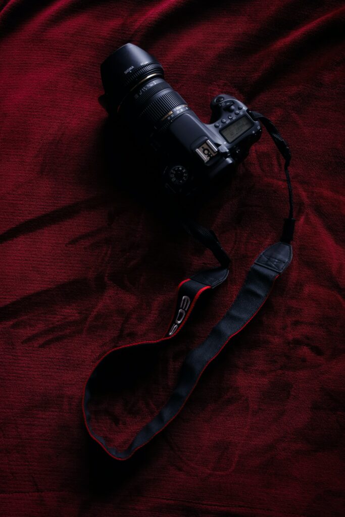 Sleek DSLR Camera with Zoom Lens on Rich Red Cloth - Wallpaper