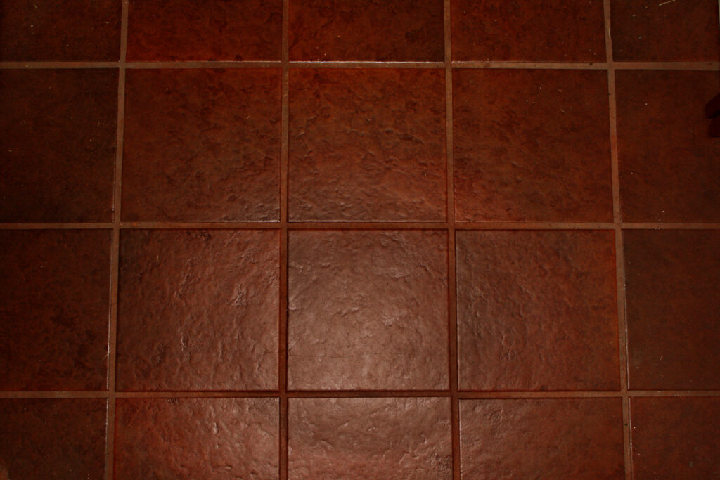 Elegant Dark Red-Brown Textured Floor Tile Wallpaper Background