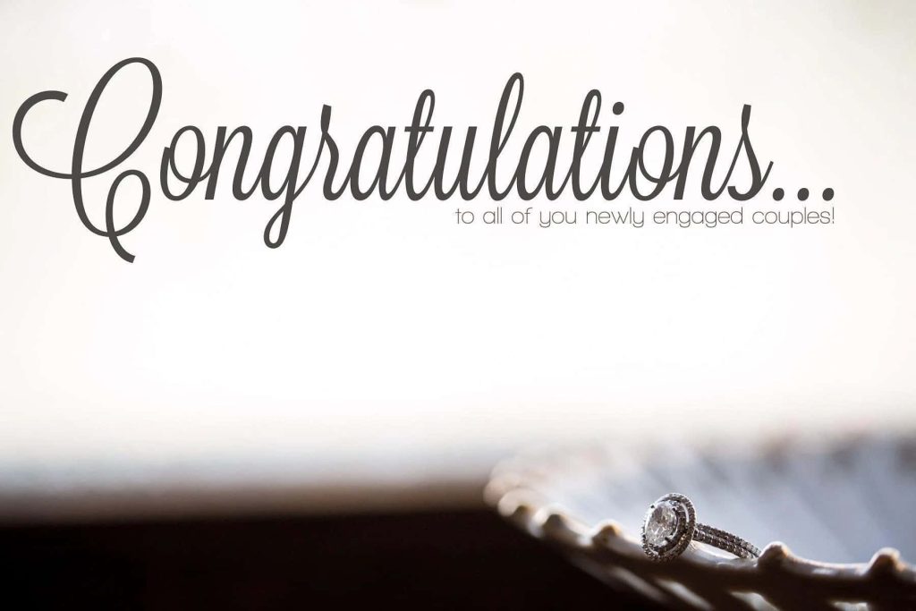Sparkling diamond engagement ring on textured surface with congratulations message background Wallpaper