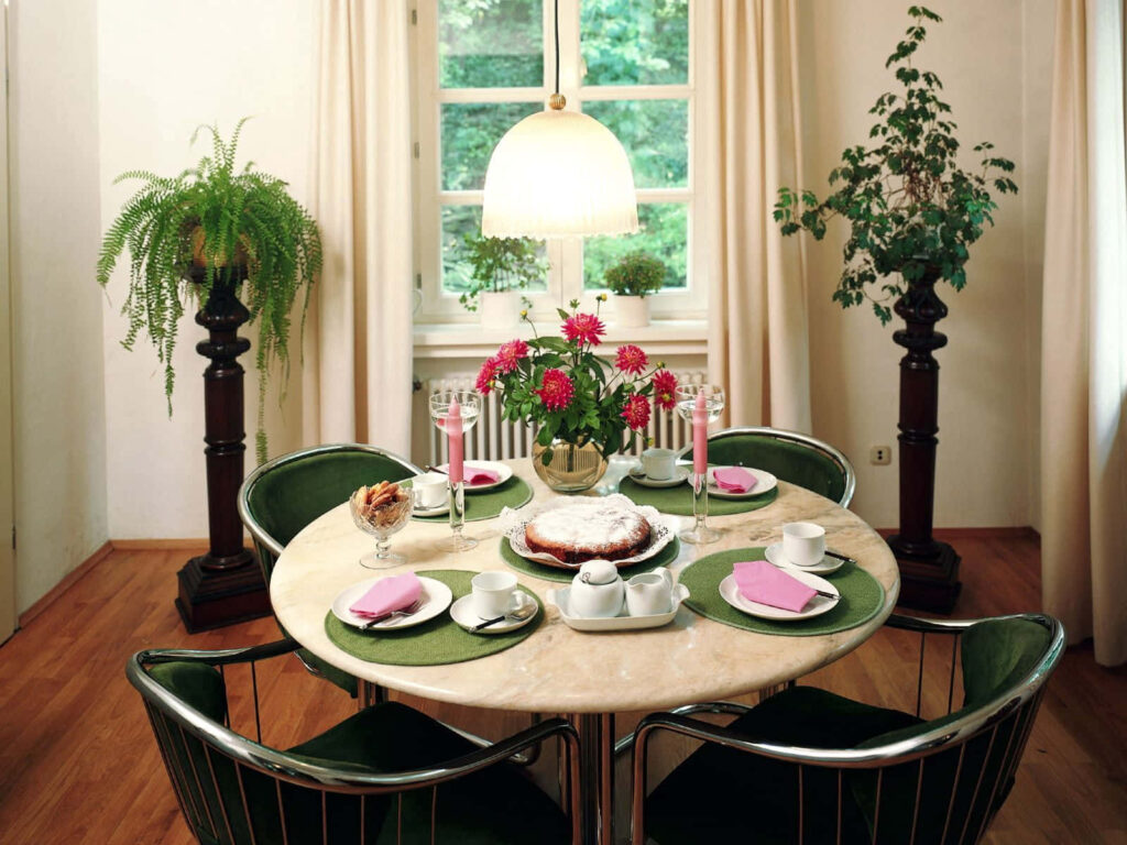 Elegant Dining Room with Round Table, Pink Napkins & Lush Greenery Wallpaper