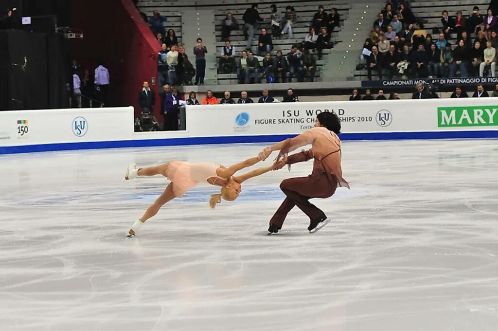 Elegant Figure Skaters in Perfect Sync - Captivating Wallpaper Background