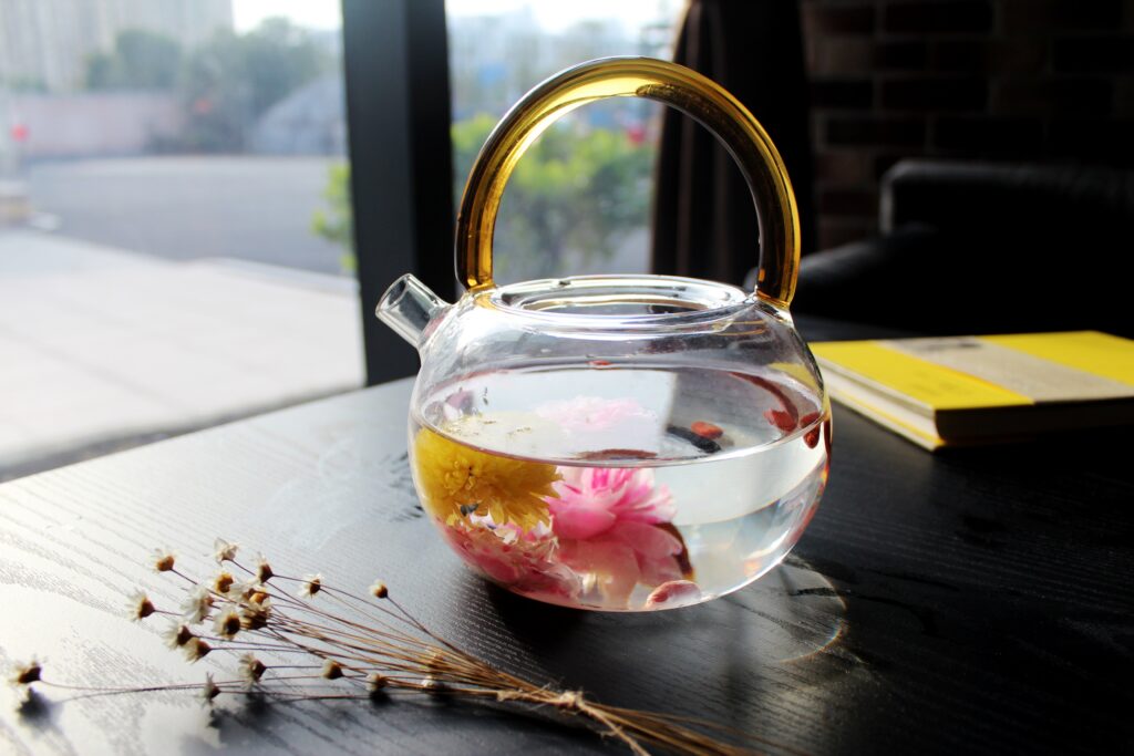 Elegant Glass Kettle with Floral Tea - Calming Atmosphere Wallpaper