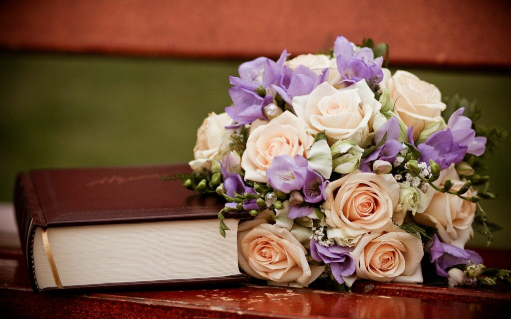 Elegant Wallpaper: Pale Roses & Purple Flowers on Leather Book Background