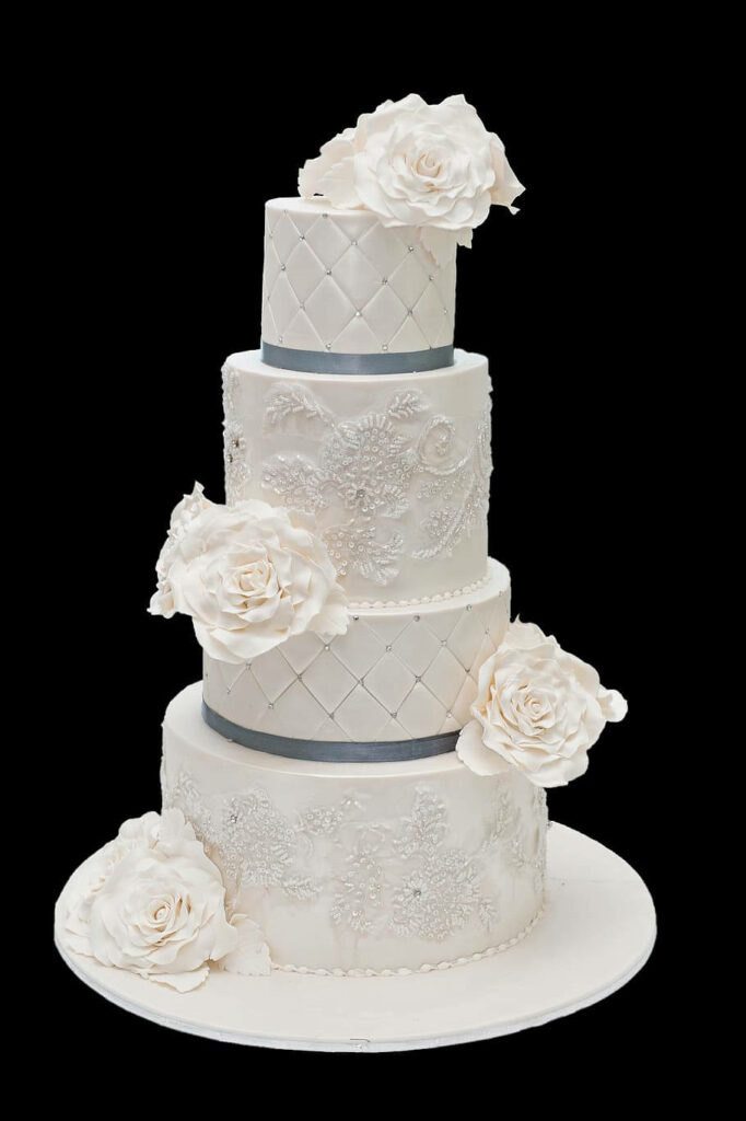 Elegant four tier wedding cake wallpaper with white lace patterns and sugar roses background