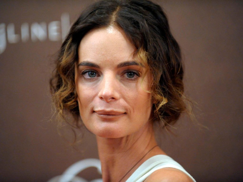 Elegant close-up portrait of actress Gabrielle Anwar with wavy highlighted brown hair and serene look Wallpaper