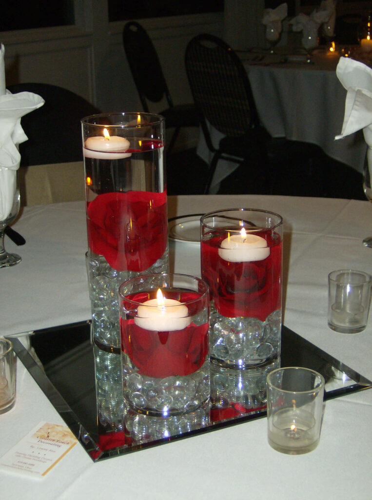 Elegant wallpaper with glass cylinders red roses floating candles on mirrored base centerpiece