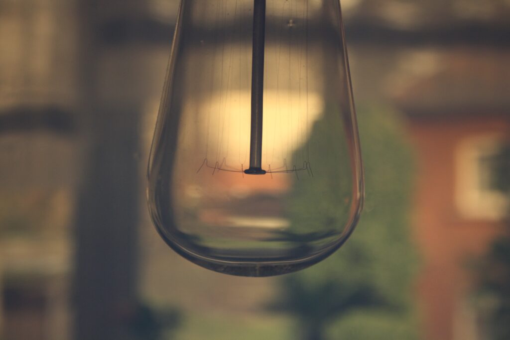 Elegant Glass Lamp Close-Up with Subtle Reflections & Blurred Wallpaper