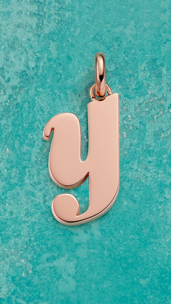 Rose gold letter Y pendant on vibrant turquoise textured wallpaper background minimal design