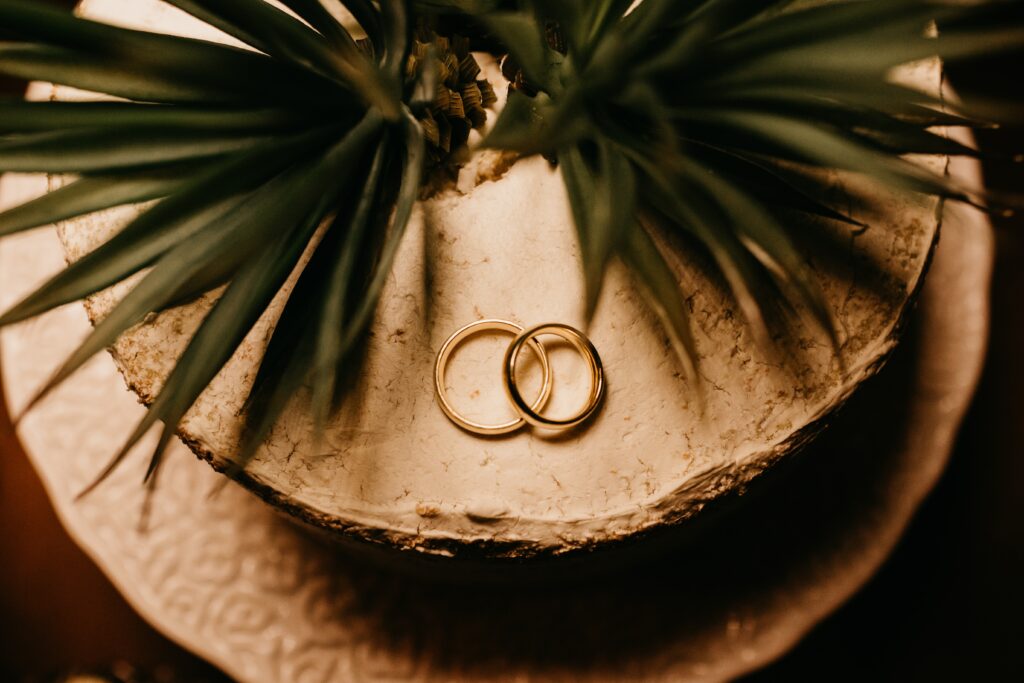Elegant Gold Rings on Textured Surface | Romantic Wedding Wallpaper