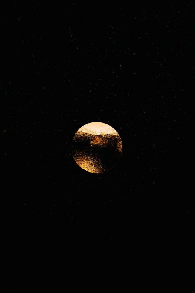 Elegant Golden Sphere Wallpaper with Cosmic Particles on Black Background
