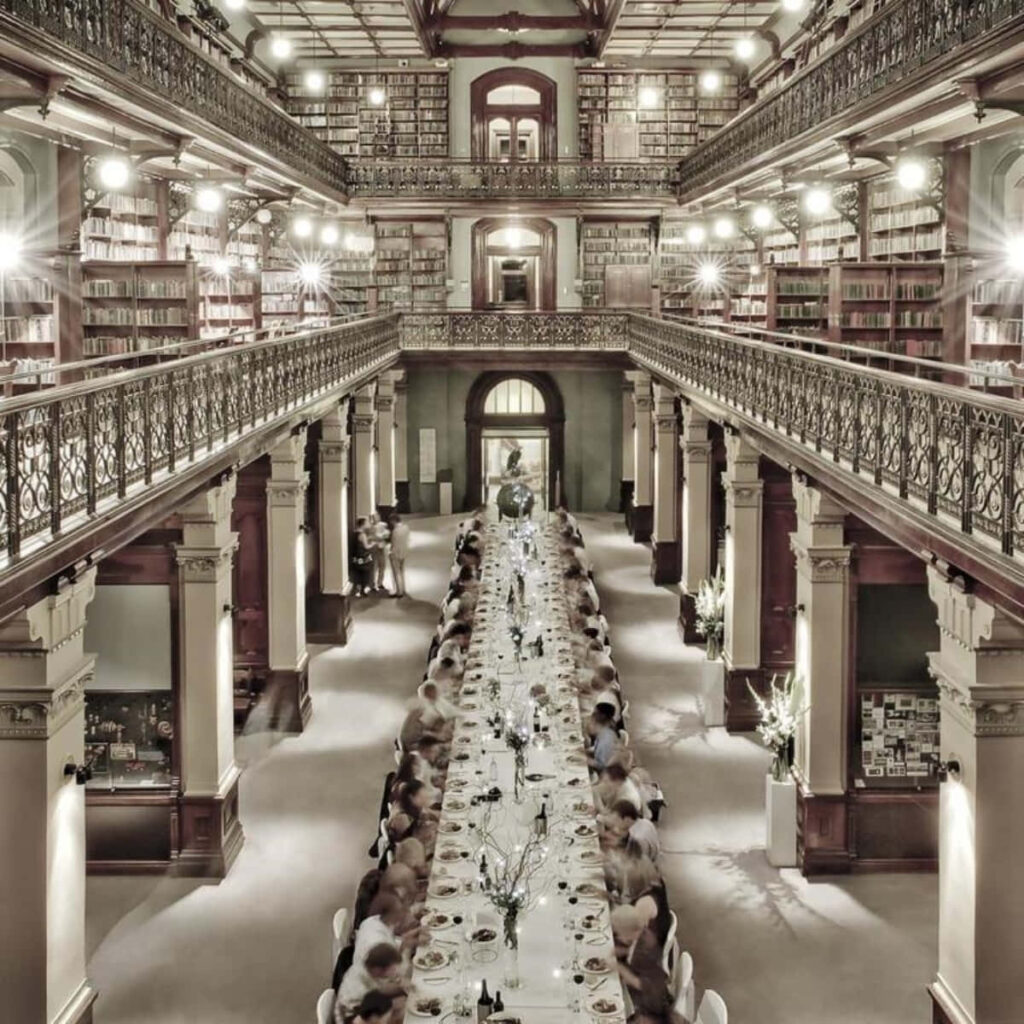 Elegant grand dinner at Adelaide State Library with ornate balconies and historic book shelves Wallpaper