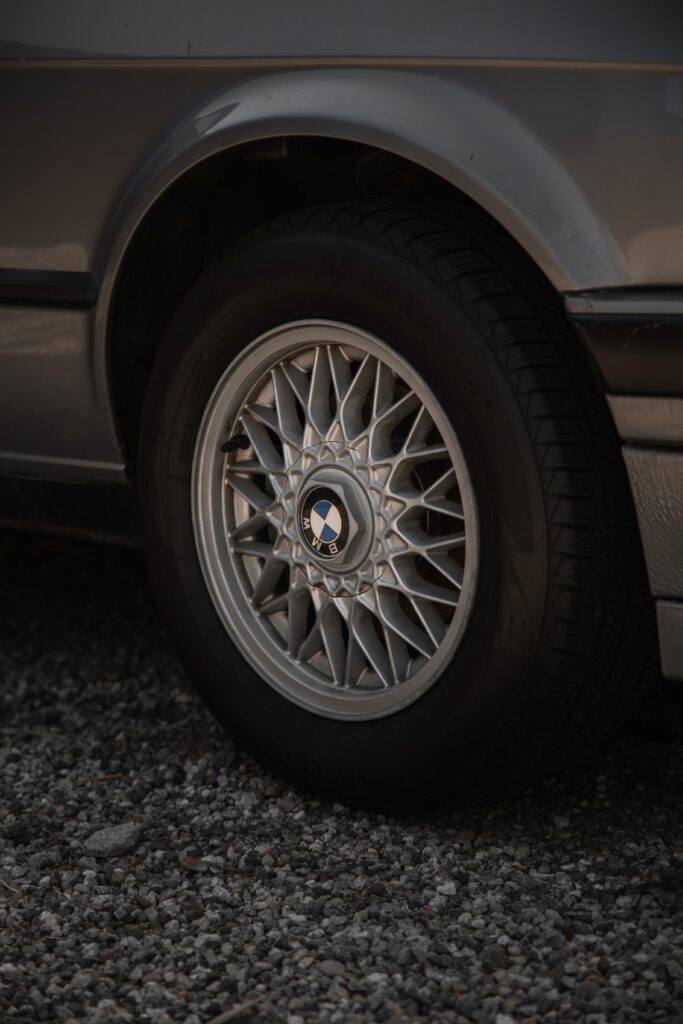 Elegant Gray BMW Close-Up: Detailed Wheel Design on Gravel Background Wallpaper
