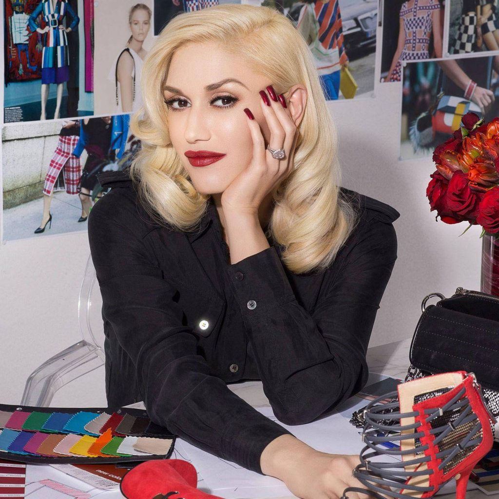 Gwen Stefani in studio with designer shoes fabric swatches red roses blonde hair red lips wallpaper