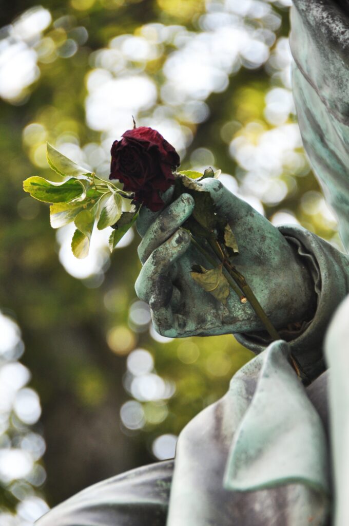 Delicate Hand Holding Rose Sculpture in Warm Sunlit Background Wallpaper