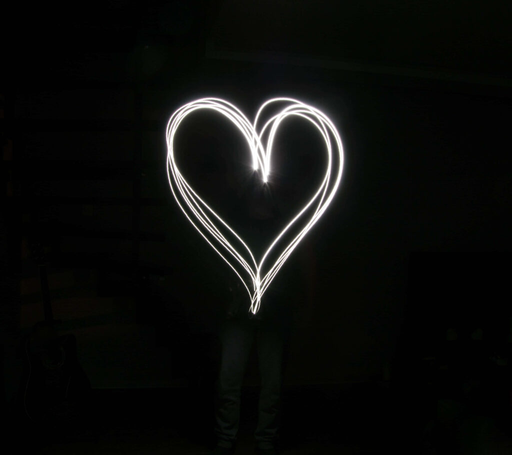 Elegant Glowing Heart Light Design Wallpaper Against Dark Background