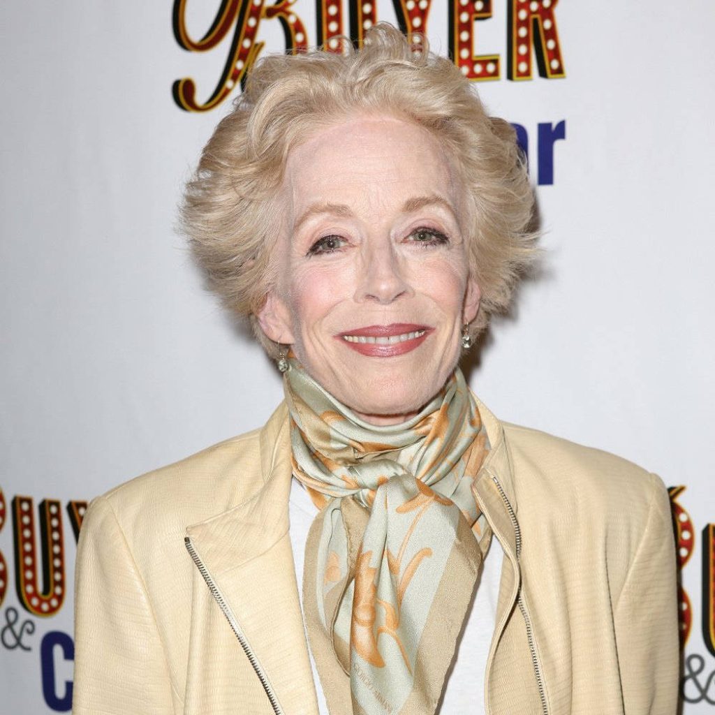 Portrait of Holland Taylor in cream jacket and patterned scarf at red carpet event with bright lighting Wallpaper