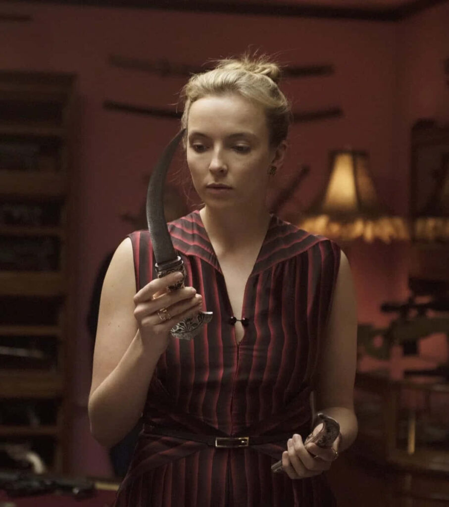 Intriguing Killing Eve Wallpaper: Elegant Danger in a Dimly Lit Scene