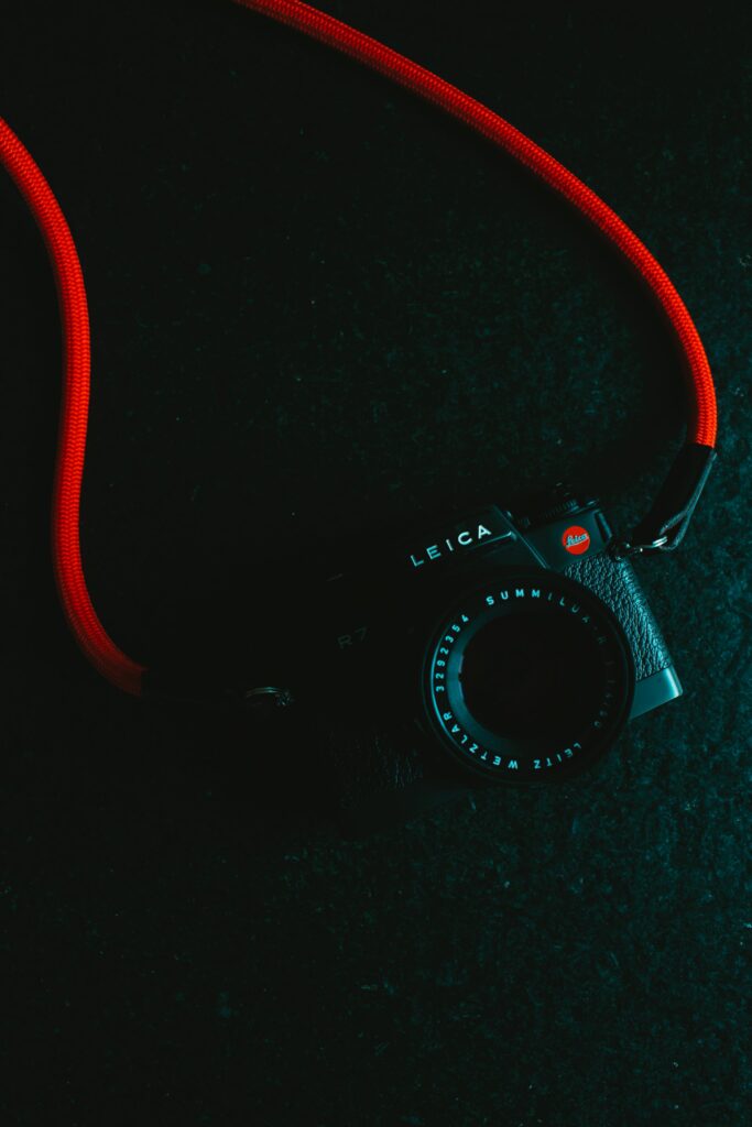 Sleek Leica R7 Camera Wallpaper with Bold Red Strap Background