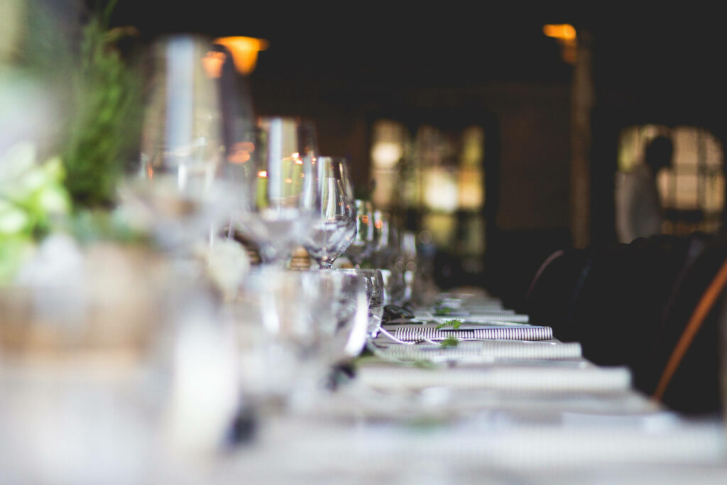 Elegant Long Table Setting with Glassware & Soft Lighting Wallpaper