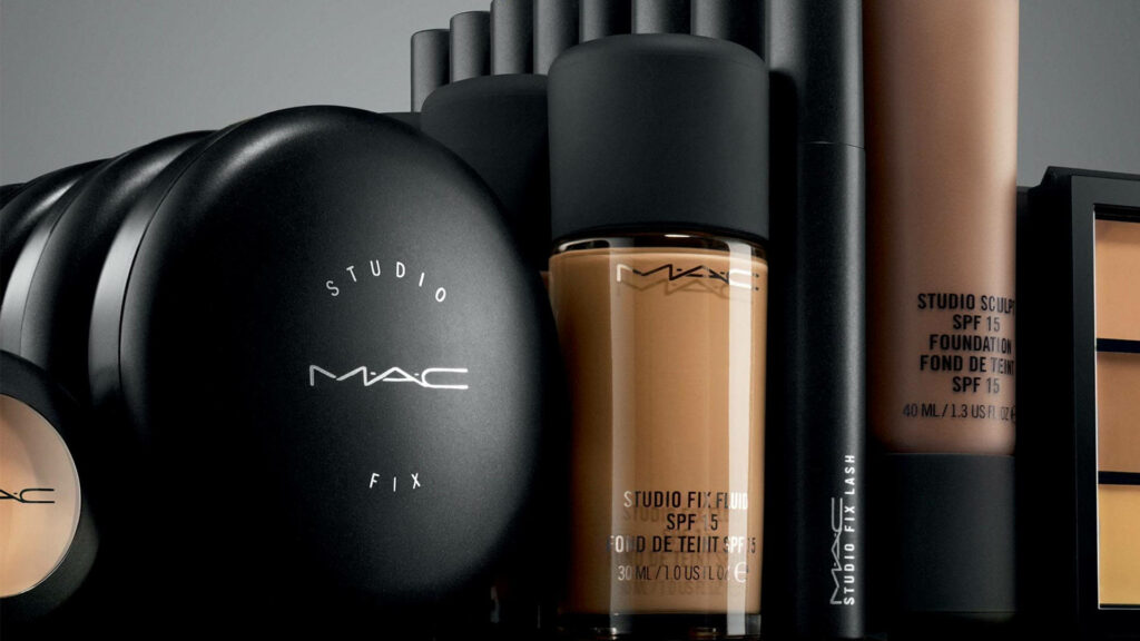 Elegant MAC makeup collection with foundation bottles and powder compacts in sleek black packaging Wallpaper