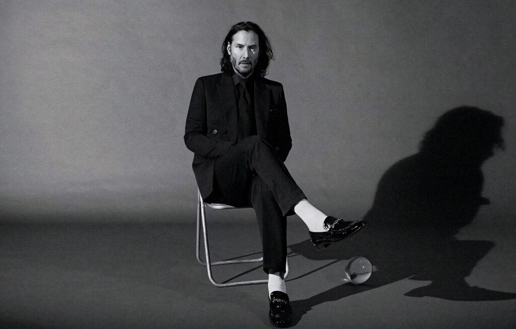 Elegant Monochrome Wallpaper of Keanu Reeves in Black Suit