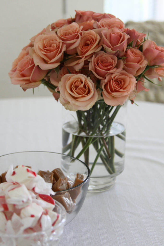Peach Roses in Glass Vase with Candy Bowl - Serene Wallpaper