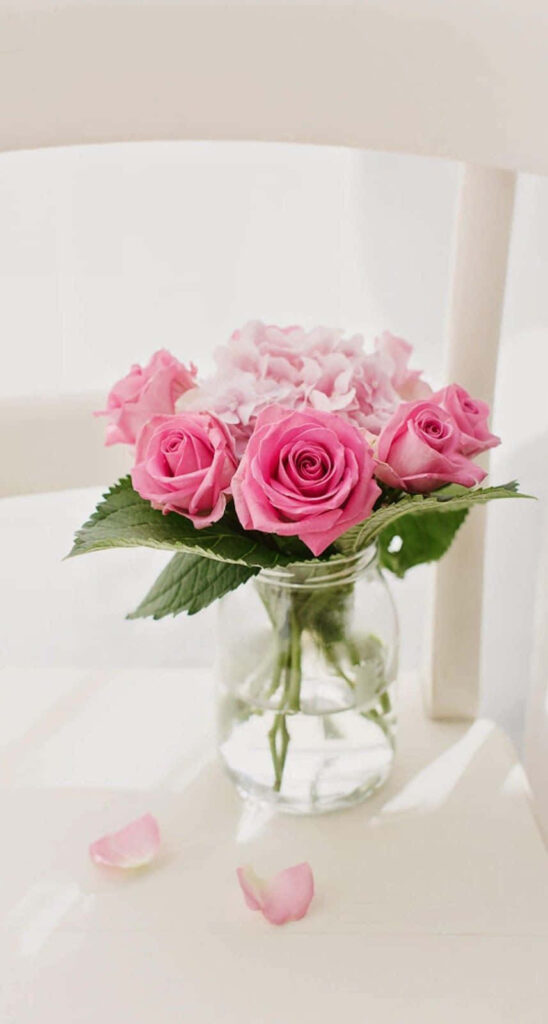 Elegant Pink Rose Bouquet in Glass Vase on White Chair – Serene Beauty Wallpaper
