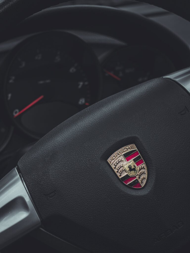 Elegant Porsche Interior Wallpaper: Iconic Steering Wheel & Speedometer
