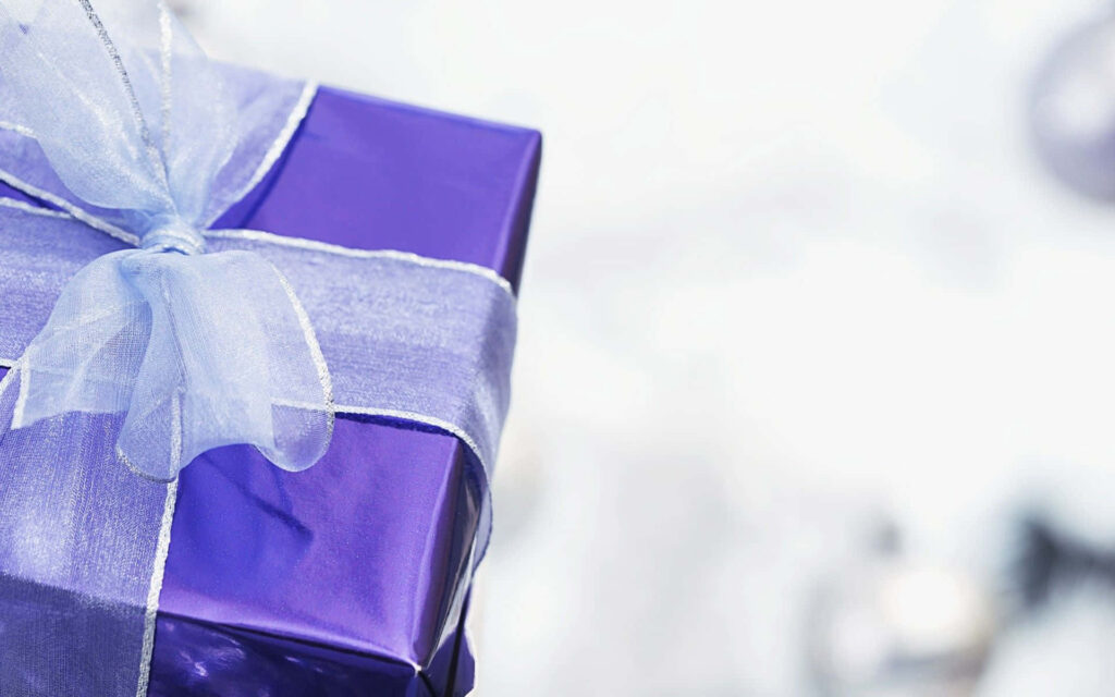 Purple gift box with white ribbon on soft blurred background festive holiday present wrap Wallpaper