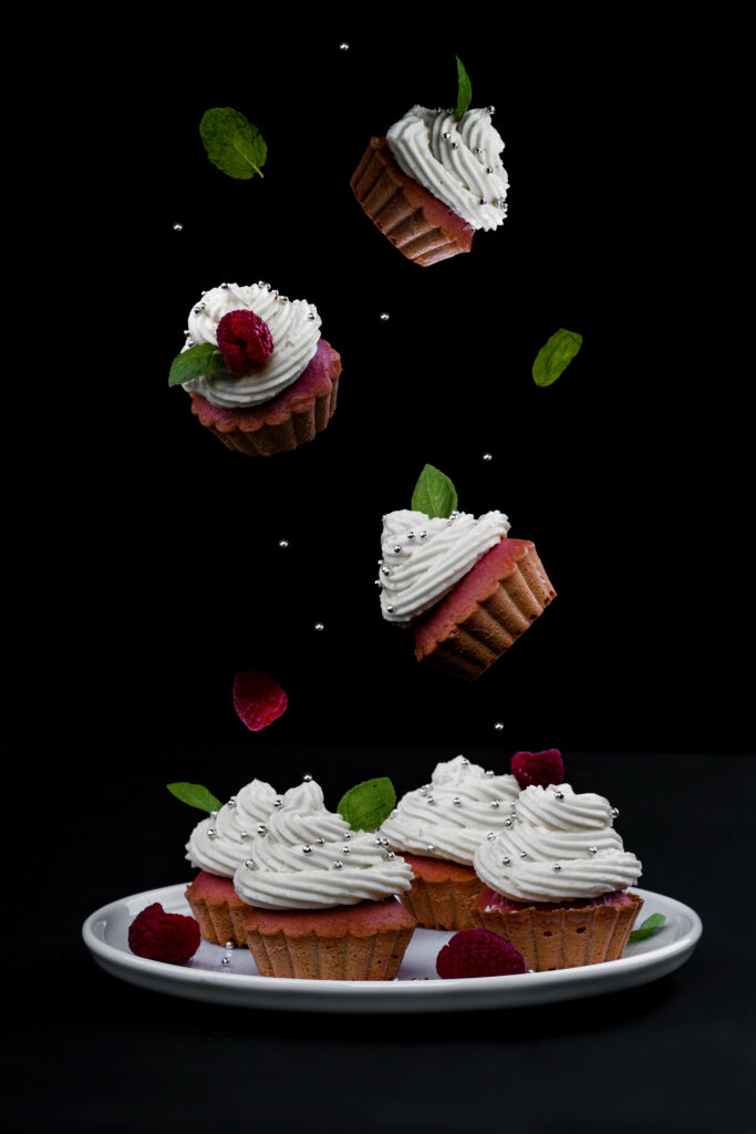 Raspberry cream cupcakes with white frosting silver sprinkles fresh mint on black background wallpaper