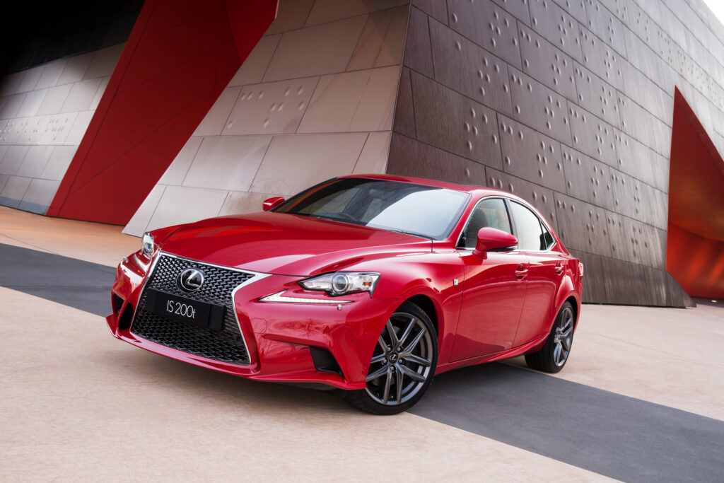 Sleek Red Lexus IS Side View Wallpaper with Elegant Architectural Background