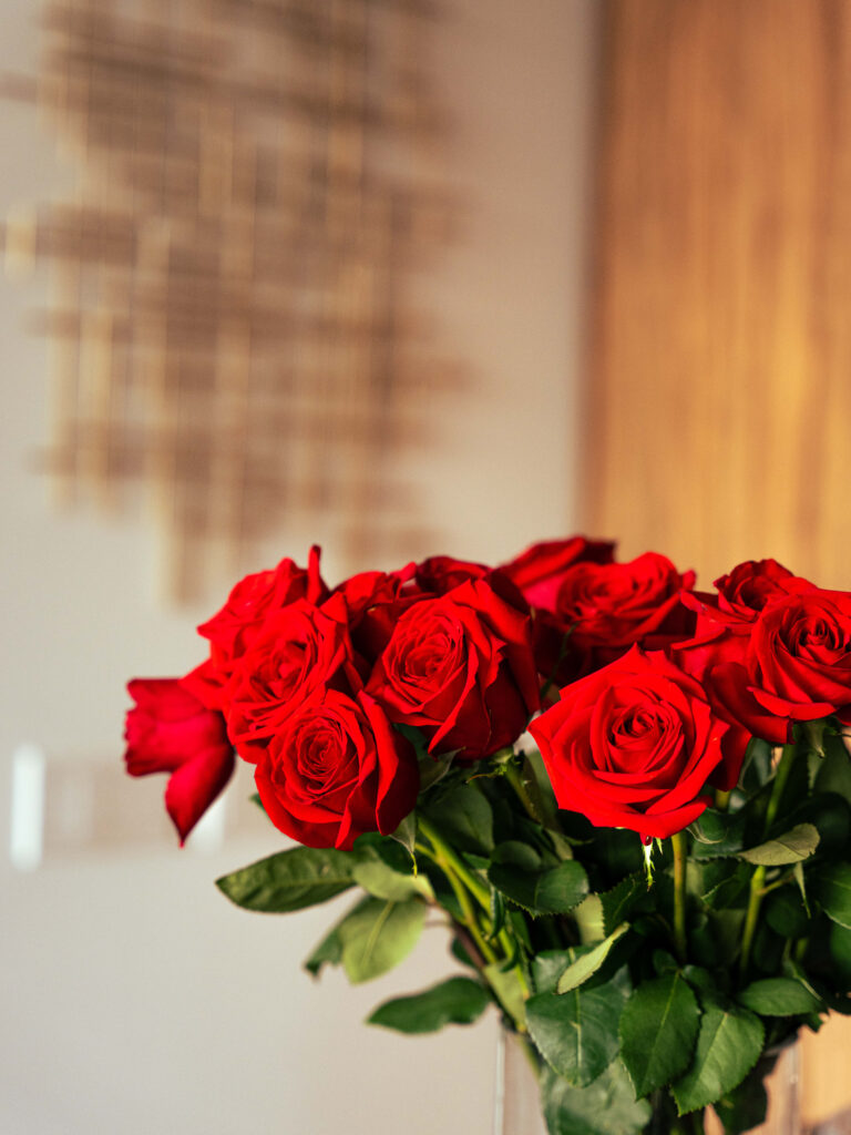 Elegant Red Roses in Glass Vase Against Soft Warm Background Wallpaper